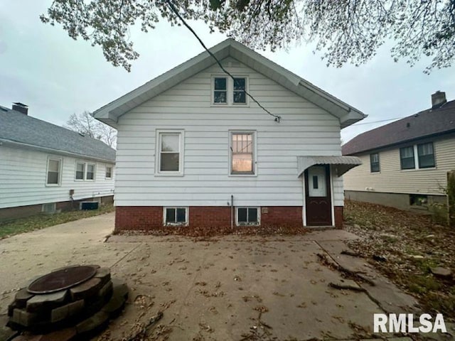 back of property featuring an outdoor fire pit and a patio