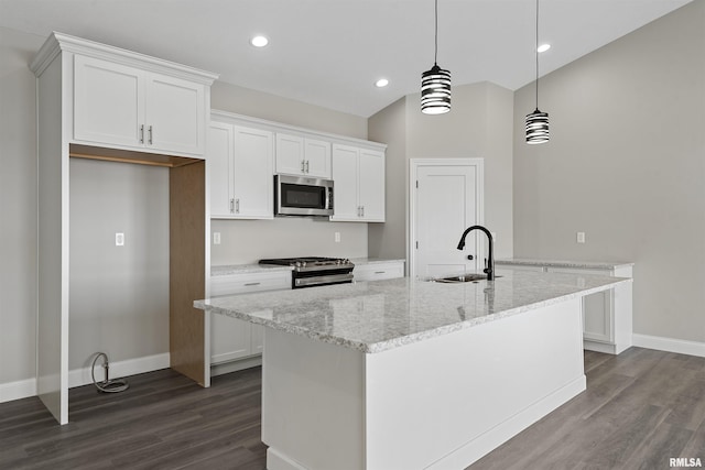 kitchen with pendant lighting, appliances with stainless steel finishes, sink, and white cabinets