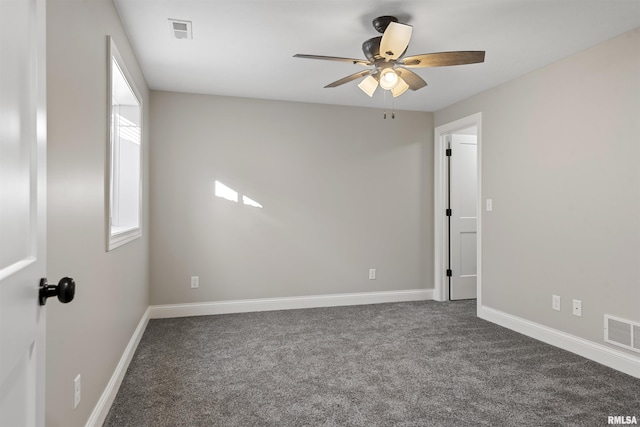 empty room featuring dark colored carpet and ceiling fan