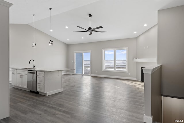 kitchen with dark wood-type flooring, lofted ceiling, hanging light fixtures, stainless steel dishwasher, and white cabinets