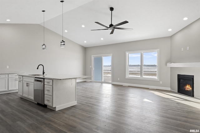 kitchen featuring white cabinetry, hanging light fixtures, light stone countertops, an island with sink, and stainless steel dishwasher