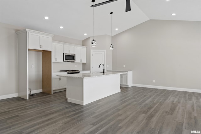 kitchen featuring pendant lighting, an island with sink, white cabinets, light stone counters, and stainless steel appliances