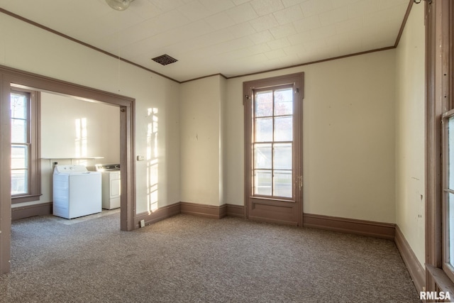 carpeted spare room featuring washing machine and dryer and ornamental molding