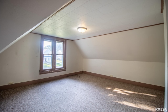 bonus room with carpet flooring and vaulted ceiling