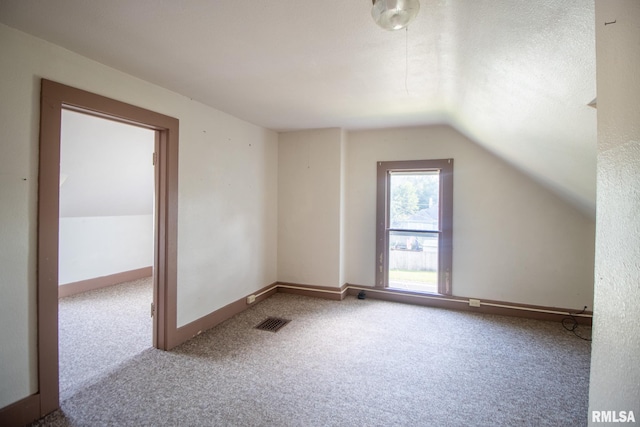 bonus room featuring carpet, vaulted ceiling, and a textured ceiling