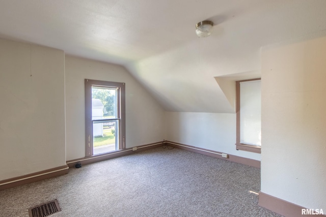 bonus room with vaulted ceiling and carpet flooring