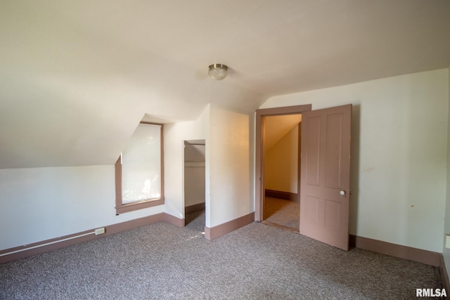 bonus room with vaulted ceiling and carpet