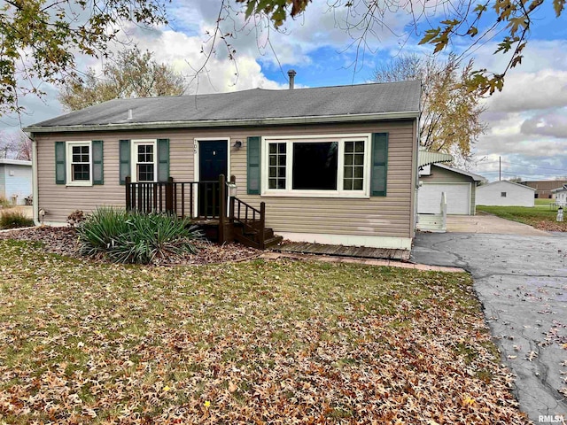 view of front of home featuring a garage, a front lawn, and an outdoor structure