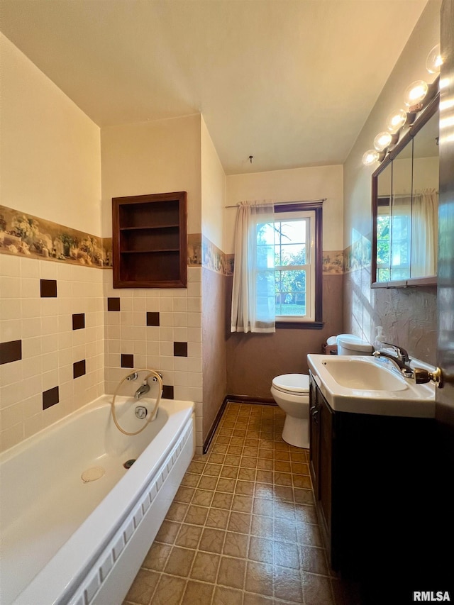 bathroom featuring a bathtub, tile walls, vanity, tile patterned flooring, and toilet