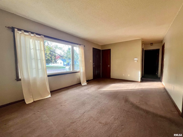 unfurnished room featuring carpet flooring and a textured ceiling