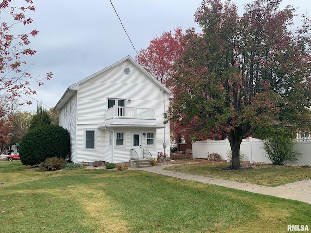 view of front of home featuring a balcony and a front lawn