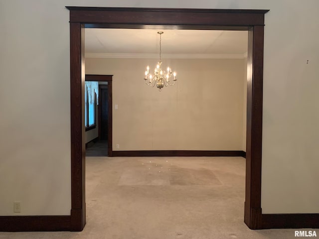 hallway featuring light colored carpet, crown molding, and an inviting chandelier