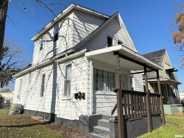 view of side of home with a porch and cooling unit