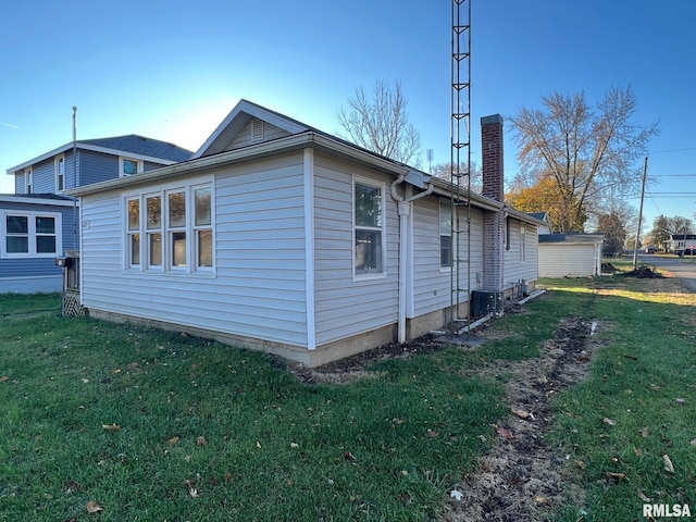 617 Short 8th St, Lincoln, IL 62656 - view of side of home featuring a yard, a chimney, and central AC