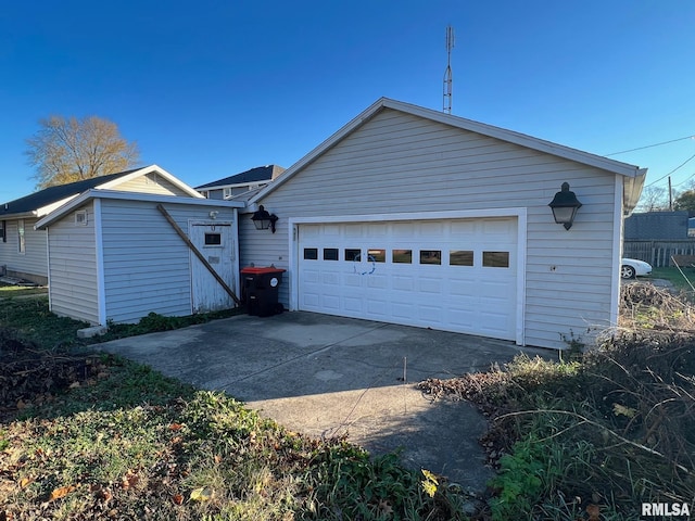 rear view of property with a garage and an outdoor structure