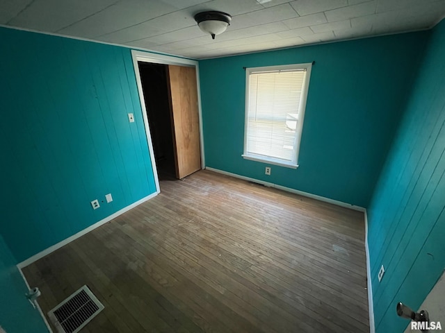 617 Short 8th St, Lincoln, IL 62656 - unfurnished bedroom featuring wood finished floors, baseboards, a closet, and wooden walls