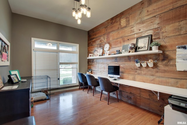 home office with wood walls, wood-type flooring, and a chandelier