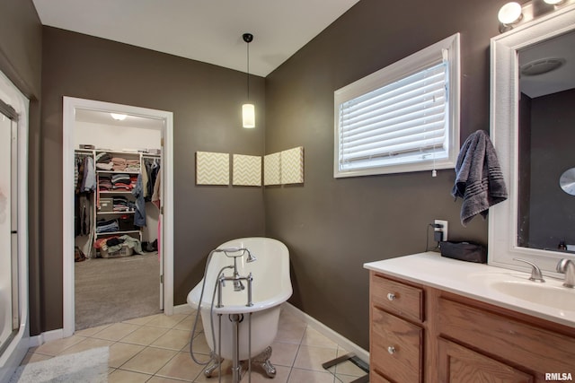 bathroom featuring a tub to relax in, vanity, and tile patterned flooring