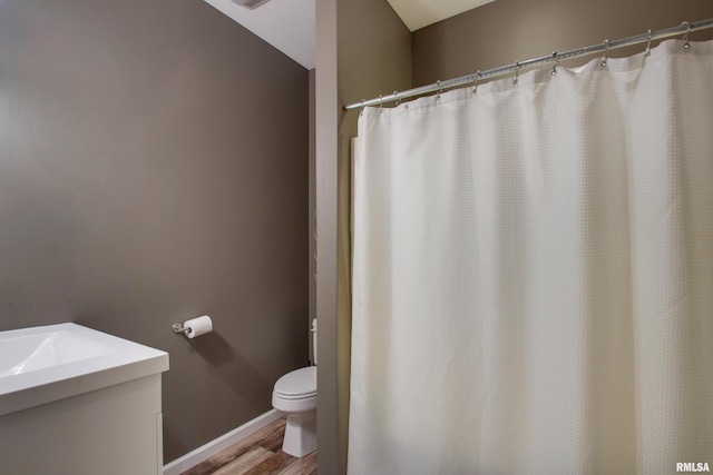 bathroom with hardwood / wood-style flooring and toilet