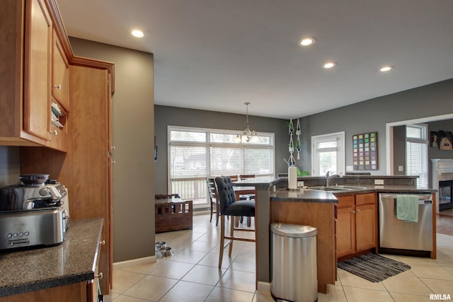 kitchen featuring stainless steel dishwasher, a healthy amount of sunlight, sink, and pendant lighting