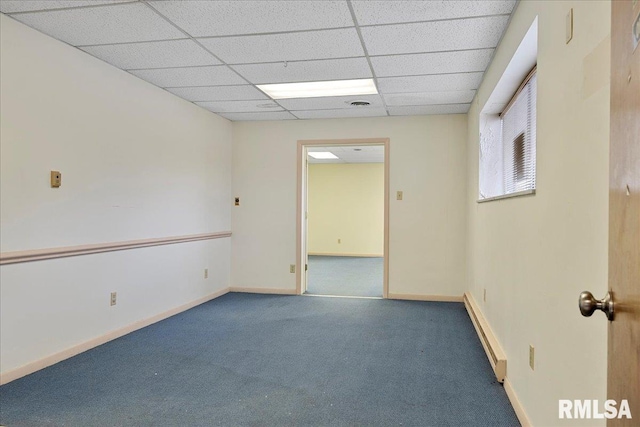 carpeted empty room featuring a drop ceiling