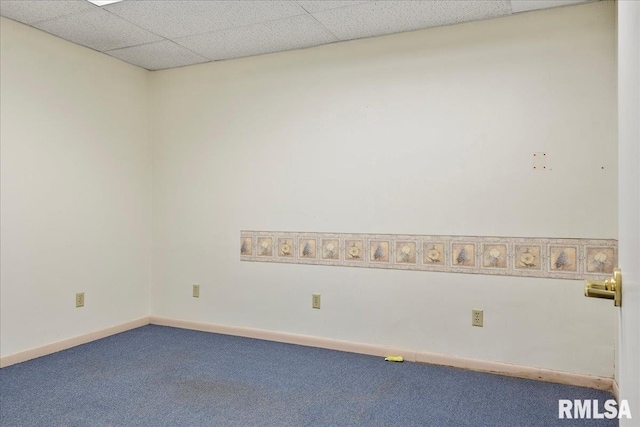 spare room featuring a drop ceiling and carpet flooring