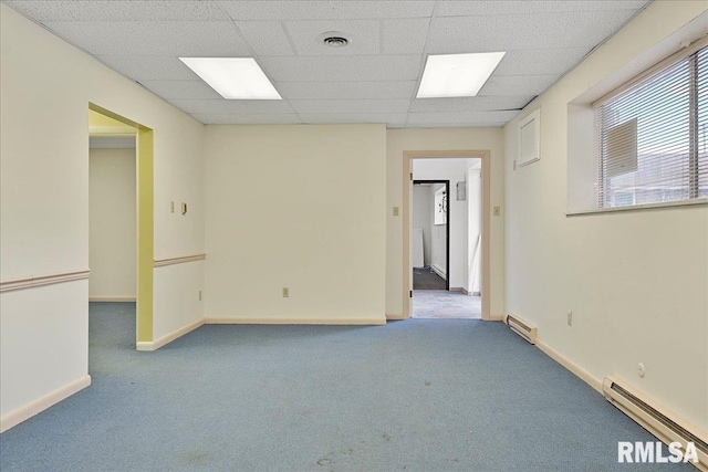 carpeted spare room featuring a baseboard radiator and a drop ceiling