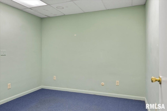 carpeted empty room featuring a paneled ceiling