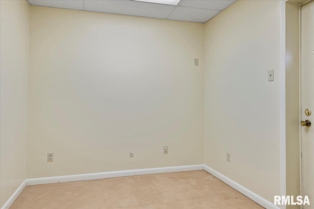 empty room with a paneled ceiling and light carpet