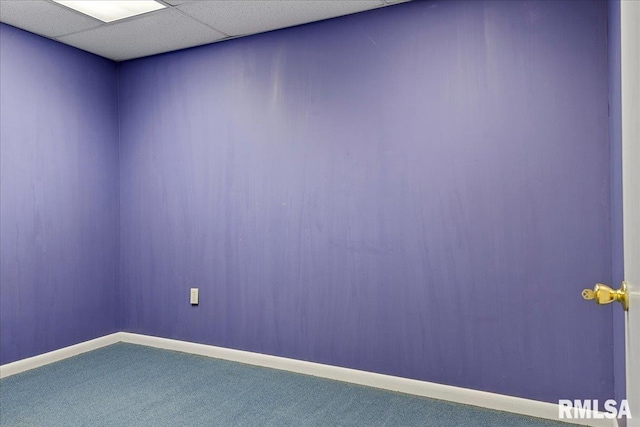 carpeted empty room featuring a drop ceiling