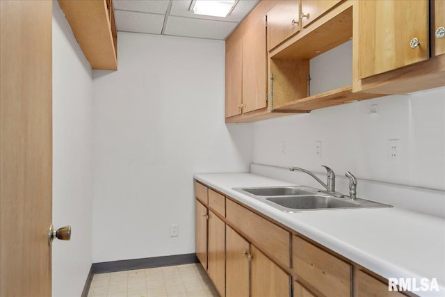 kitchen with a paneled ceiling and sink