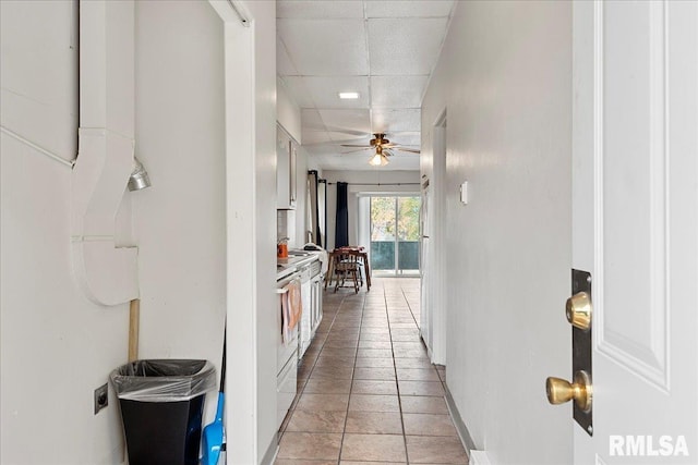 hallway featuring light tile patterned flooring and a drop ceiling