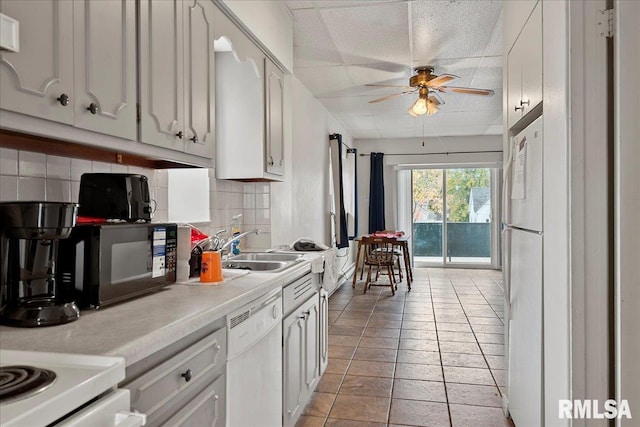 kitchen with tasteful backsplash, white cabinetry, light tile patterned floors, white appliances, and ceiling fan