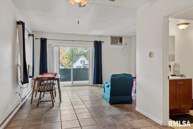 interior space featuring light tile patterned flooring, a wall mounted AC, and a paneled ceiling