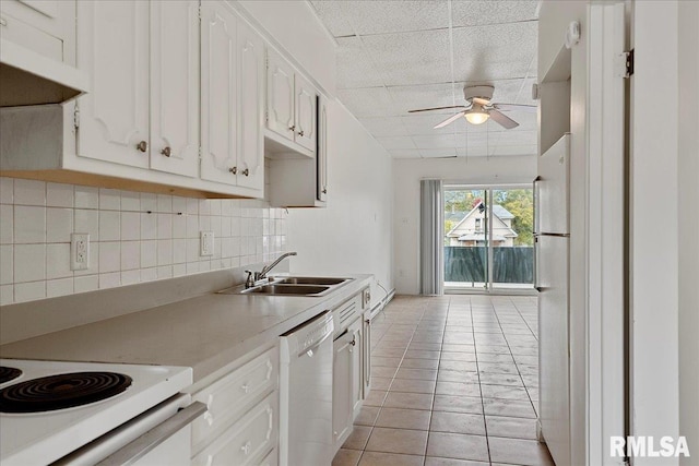 kitchen featuring sink, tasteful backsplash, light tile patterned floors, white cabinets, and dishwasher