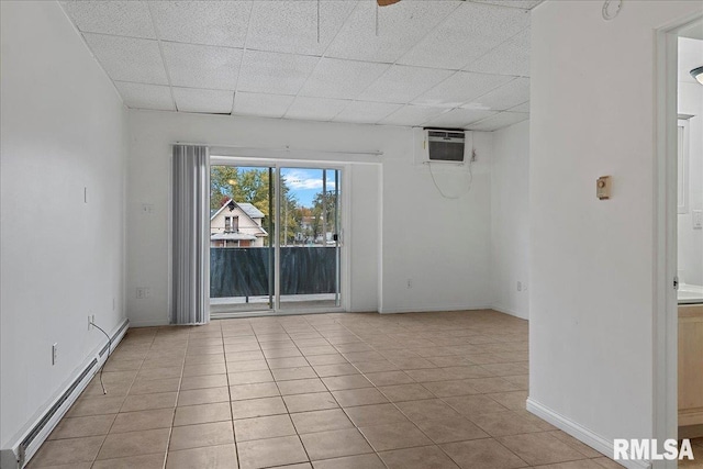 tiled spare room featuring a drop ceiling and baseboard heating