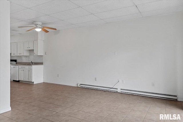 unfurnished living room featuring a paneled ceiling, sink, baseboard heating, ceiling fan, and light tile patterned flooring