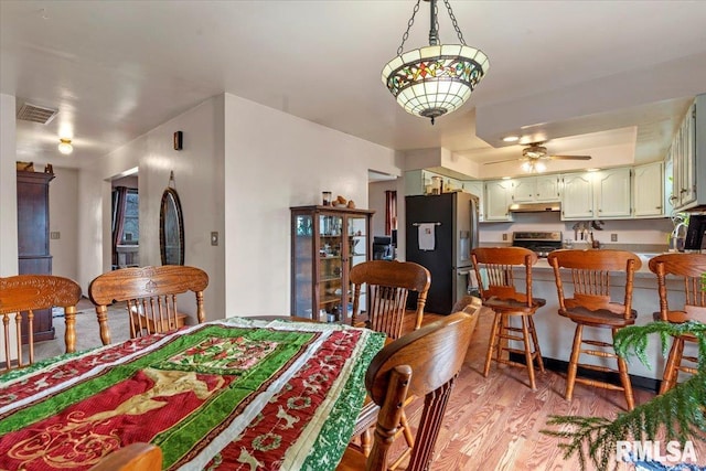 dining area with light hardwood / wood-style flooring and ceiling fan