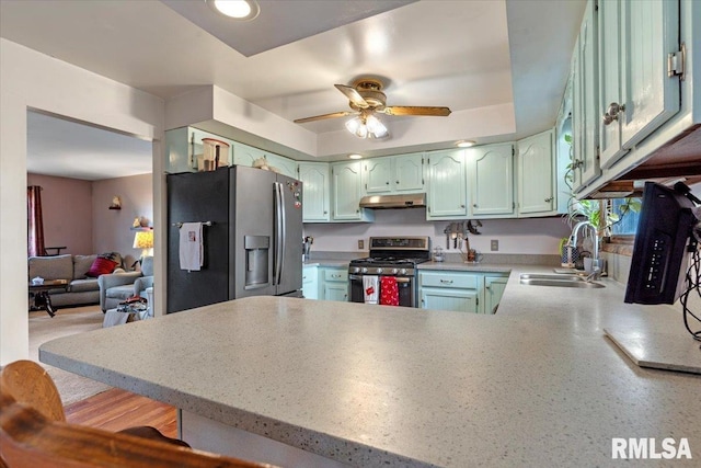 kitchen featuring kitchen peninsula, stainless steel appliances, ceiling fan, and sink