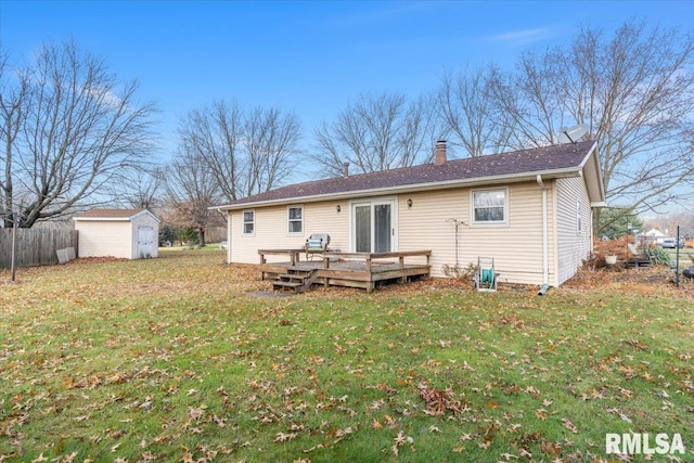 rear view of house with a yard, a deck, and a storage shed