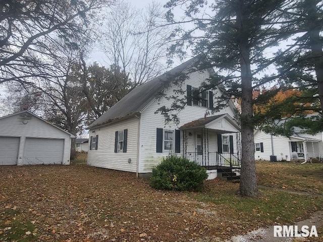 view of front of house with a garage and an outbuilding