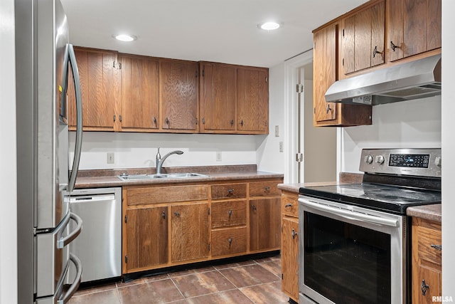 kitchen with sink, dark tile patterned floors, and appliances with stainless steel finishes