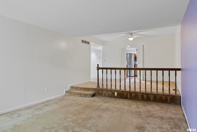 carpeted spare room featuring ceiling fan