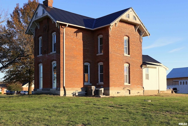 view of home's exterior featuring cooling unit and a lawn