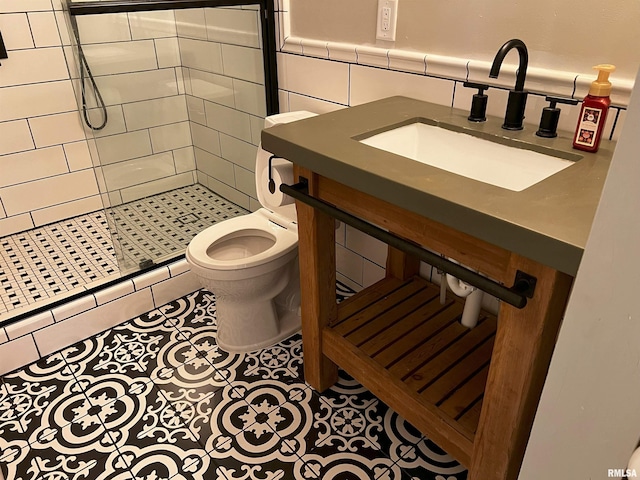 bathroom featuring tile patterned floors, sink, tile walls, toilet, and a shower with shower door