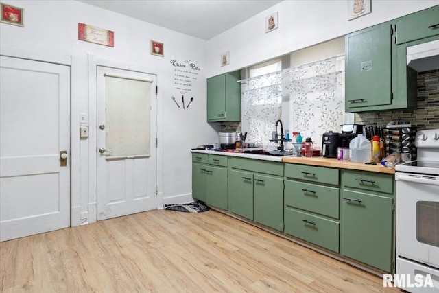 kitchen with green cabinets, sink, tasteful backsplash, white electric range oven, and light hardwood / wood-style floors