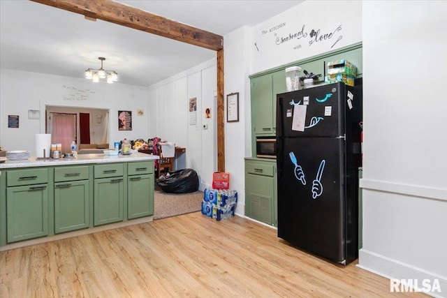 kitchen with beam ceiling, a notable chandelier, light hardwood / wood-style floors, black refrigerator, and green cabinetry