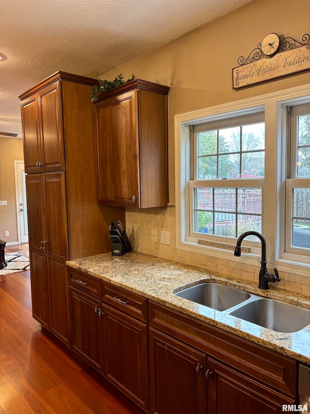 kitchen featuring dark hardwood / wood-style floors, plenty of natural light, sink, and tasteful backsplash