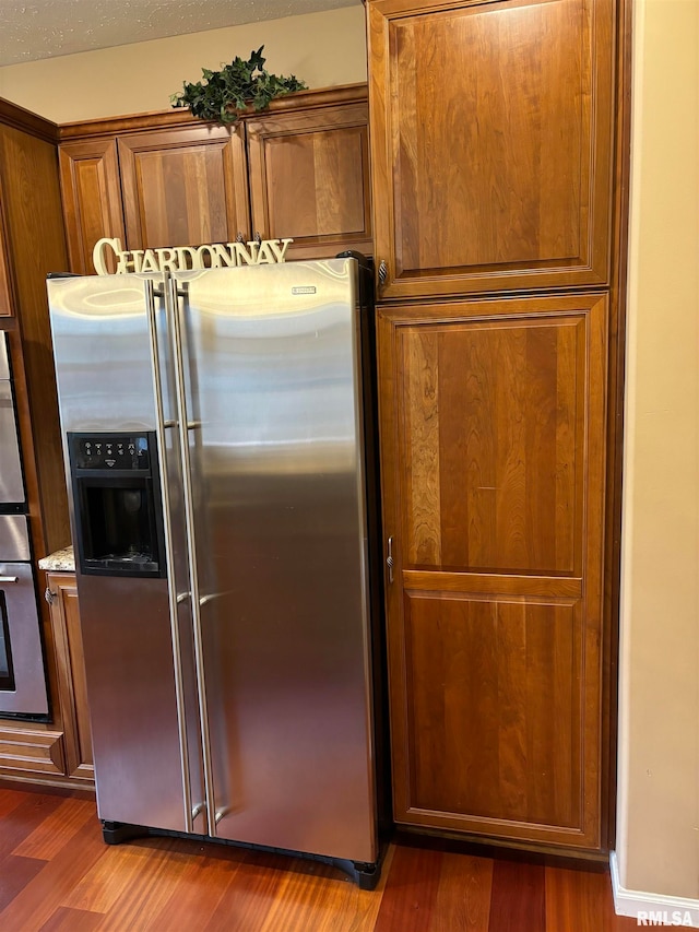 kitchen featuring stainless steel fridge and dark hardwood / wood-style floors