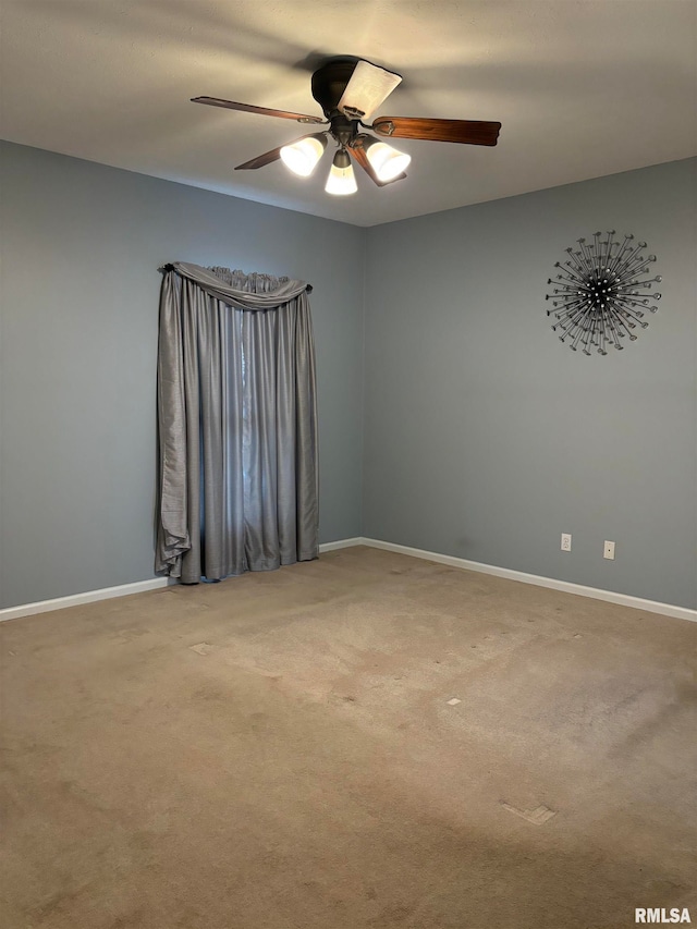 carpeted spare room with ceiling fan